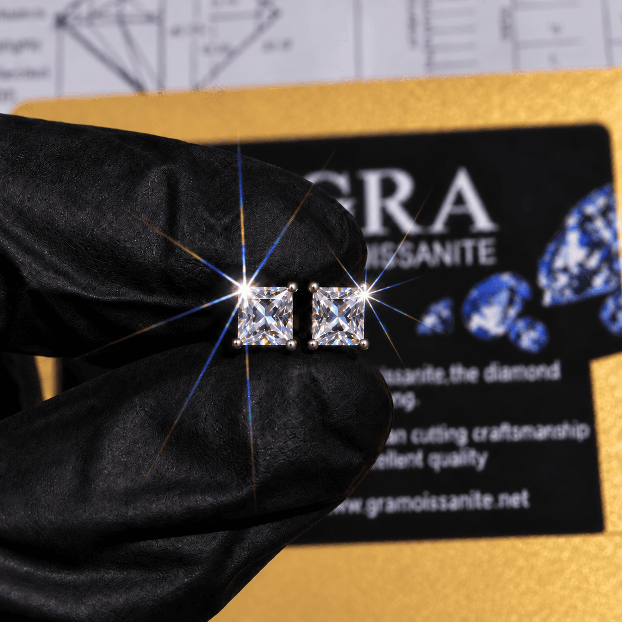 Princess cut moissanite stud earrings held in front of a GRA certificate card